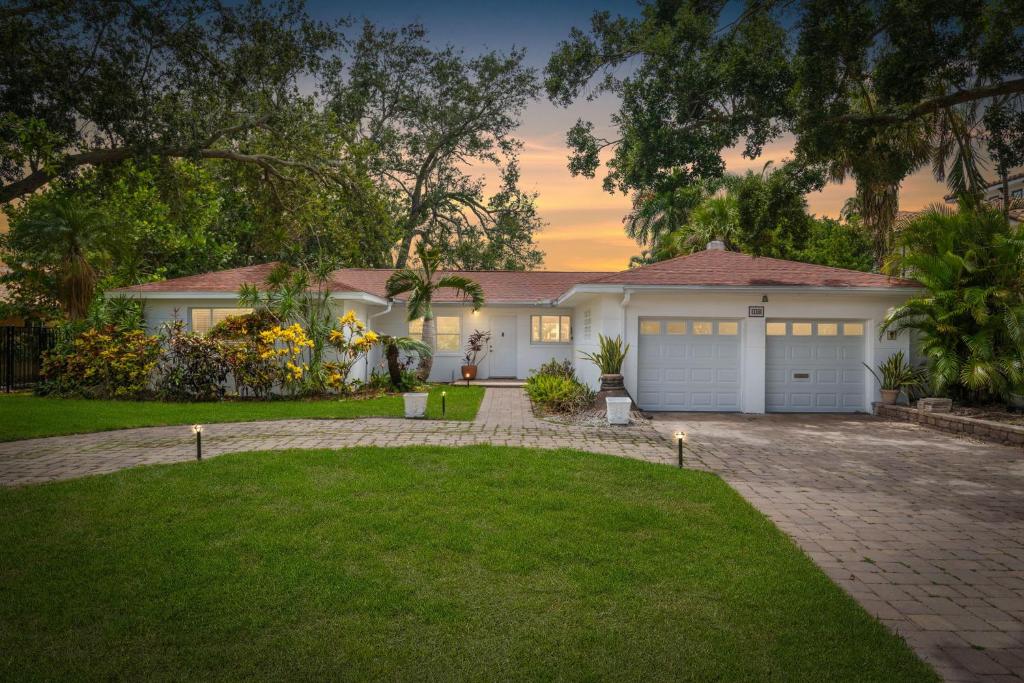 una casa con dos puertas de garaje y un camino de entrada en 3BR Waterfront Gem Pool Dog Friendly, en San Petersburgo