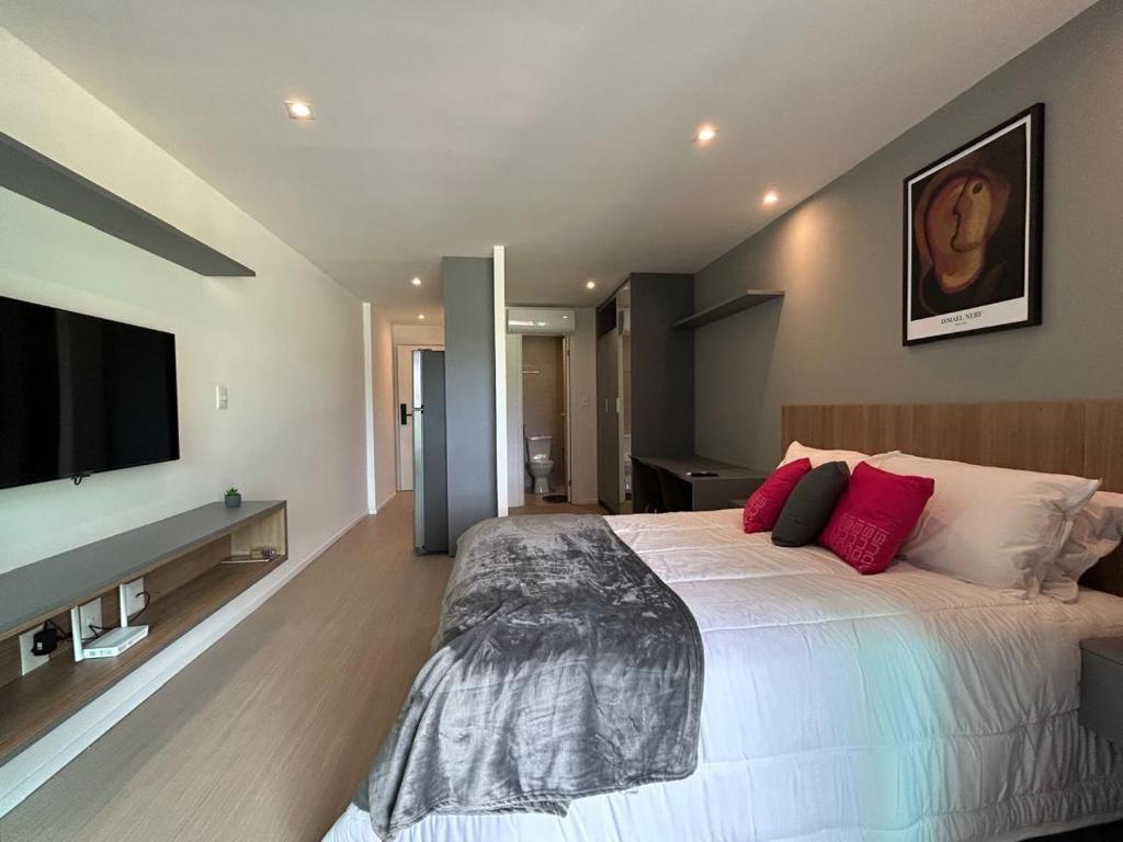 une chambre avec un grand lit et une télévision à écran plat dans l'établissement Lindo studio frente mar!, à Salvador