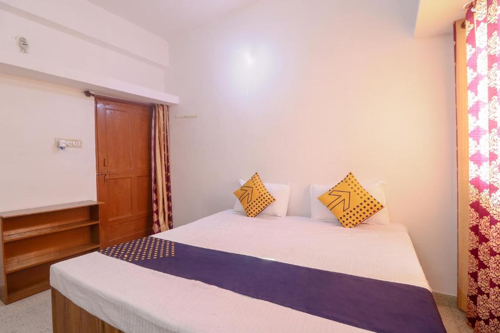 1 dormitorio con 1 cama con almohadas amarillas y azules en SPOT ON Hotel Om Kanha, en Bilāspur