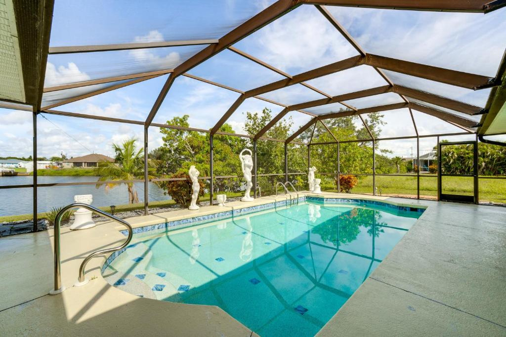a large swimming pool with a large glass roof at 4 Mi to Port C Beach Park! Classy Canal-Front Home in Port Charlotte