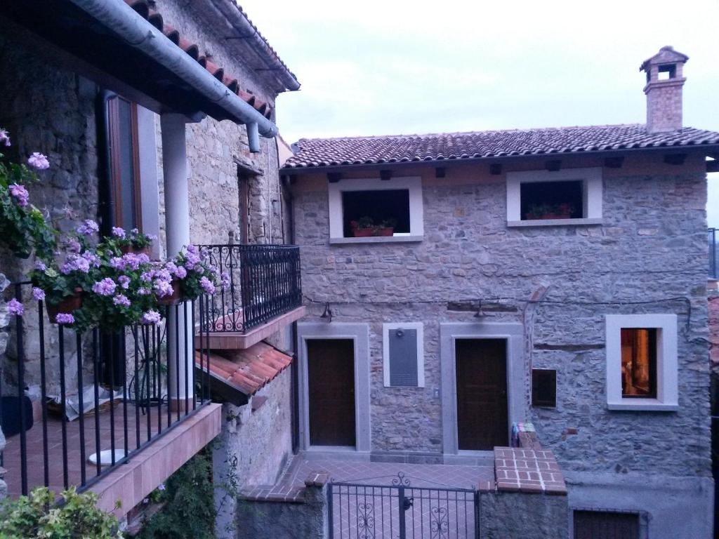 een oud stenen huis met balkons en bloemen bij Il Borghetto Antico in Cuccaro Vetere