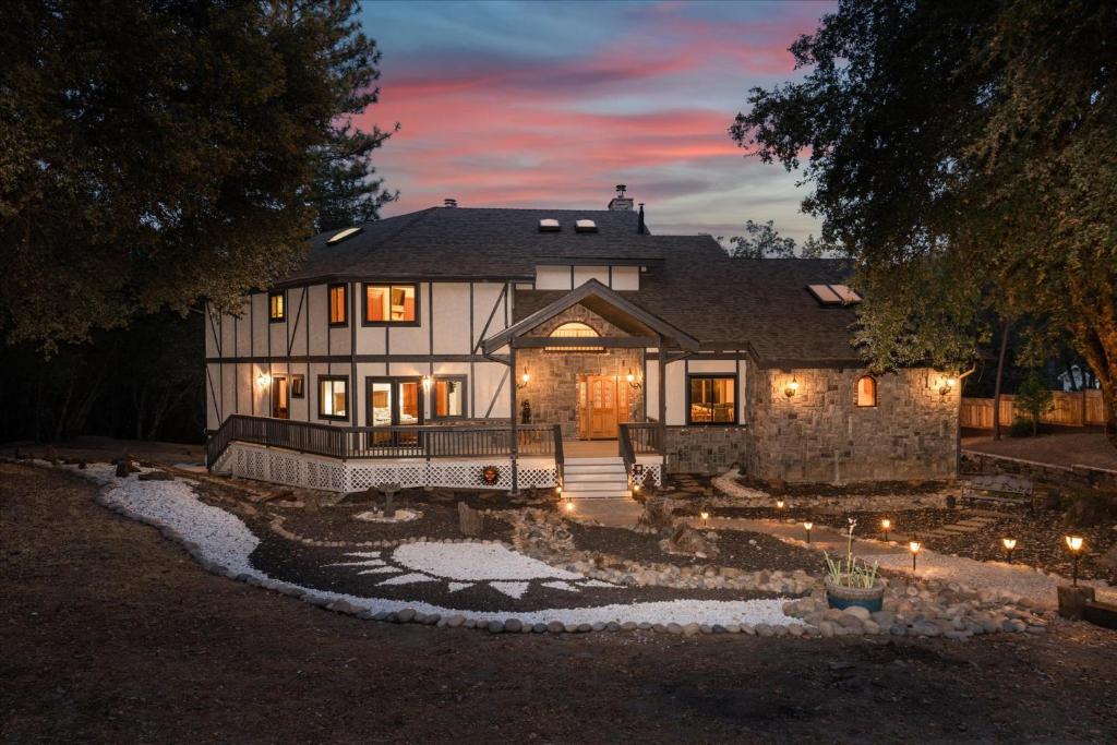 a large house with lights in the yard at night at Greystone Manor- HUGE home with sleeping for 21 in Oakhurst