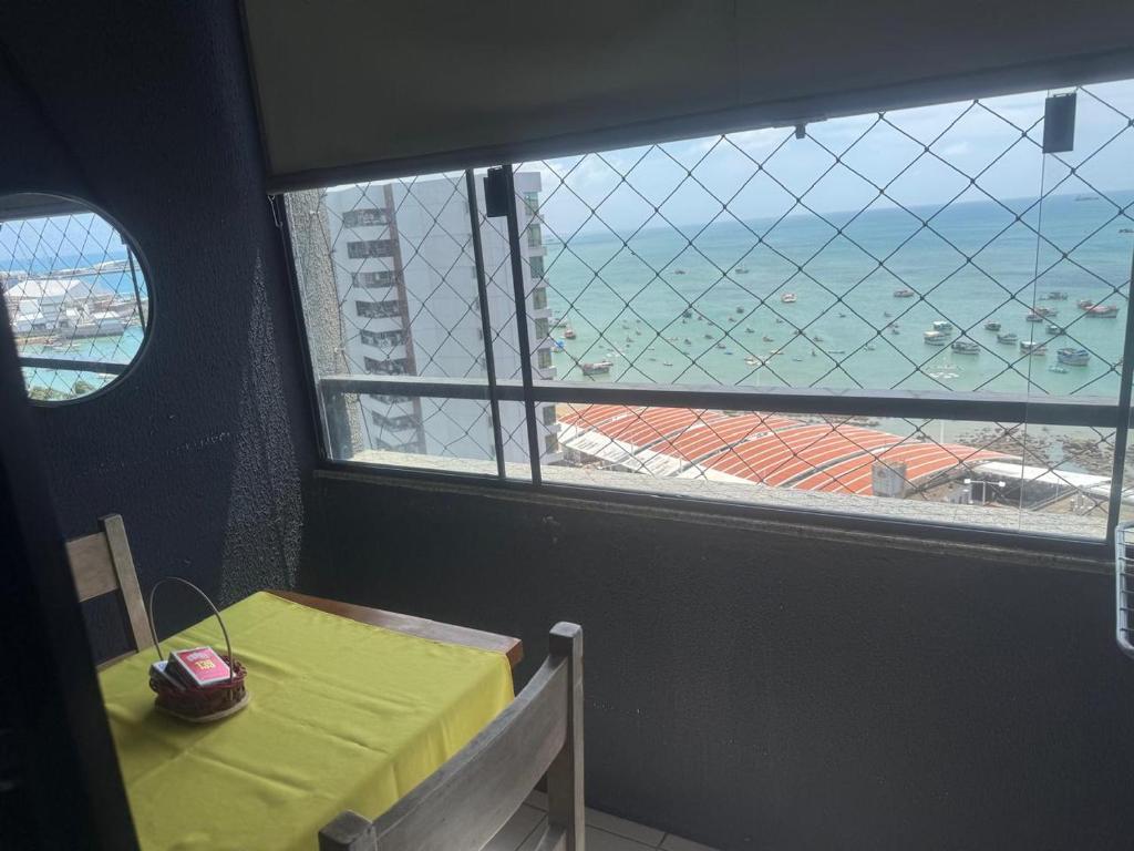 a table and a window with a view of the ocean at Apartamento vista mar no mucuripe in Fortaleza