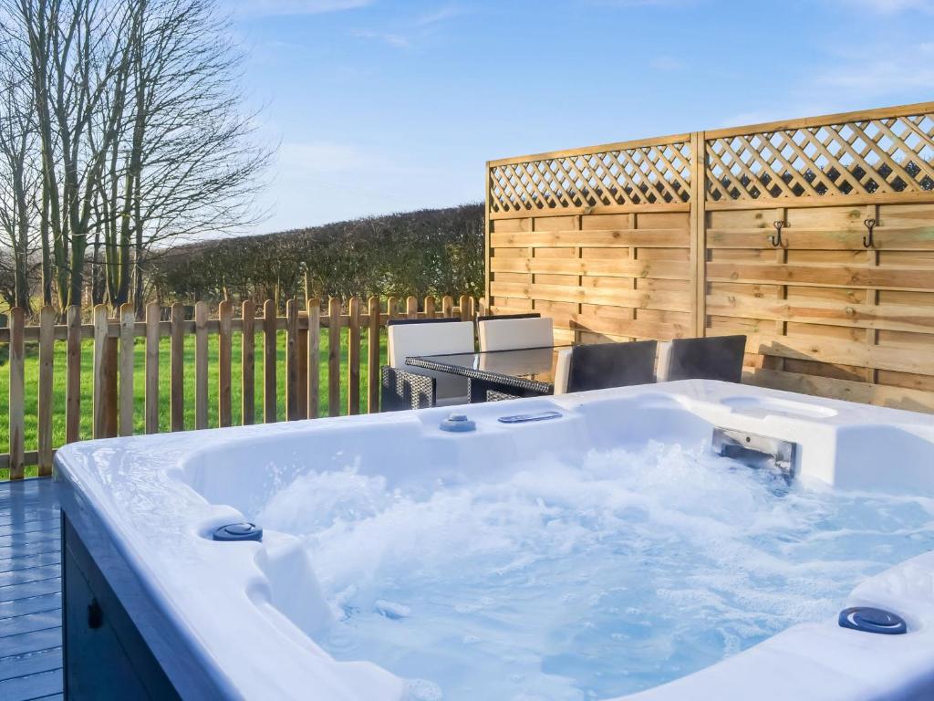a hot tub in a backyard with a wooden fence at Beech - Uk47622 in Hunmanby