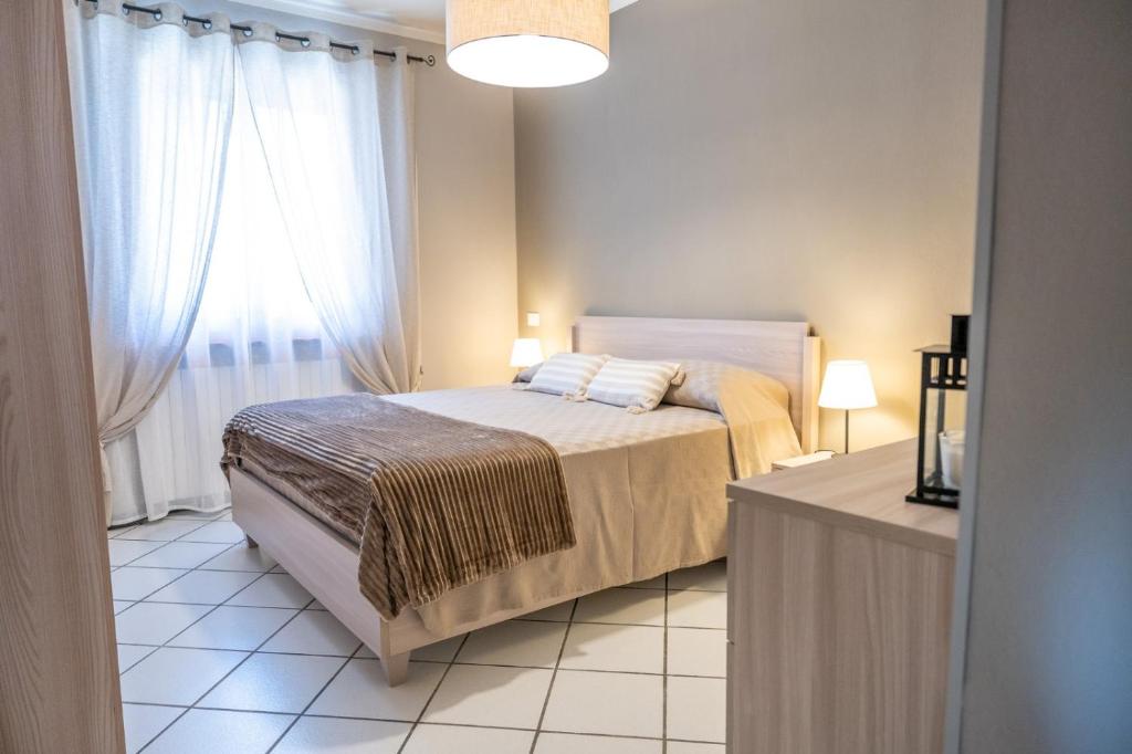 a bedroom with a bed and a large window at La casa di Emilia in Lucca