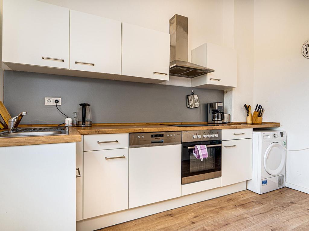 a kitchen with white cabinets and a dishwasher at Breite Str 154 Selm in Selm