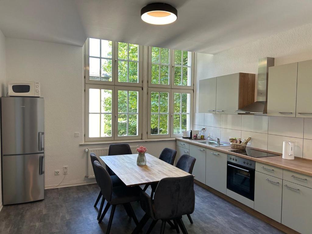 eine Küche mit einem Tisch und Stühlen in einer Küche in der Unterkunft Come Stay Relax Apartment für bis zu 6 Personen - Parkplatz - WLAN - Homeoffice in Trier