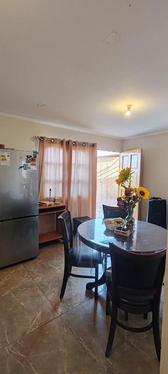 a kitchen with a table and chairs and a refrigerator at La casa de Silvana in San Pedro de Atacama