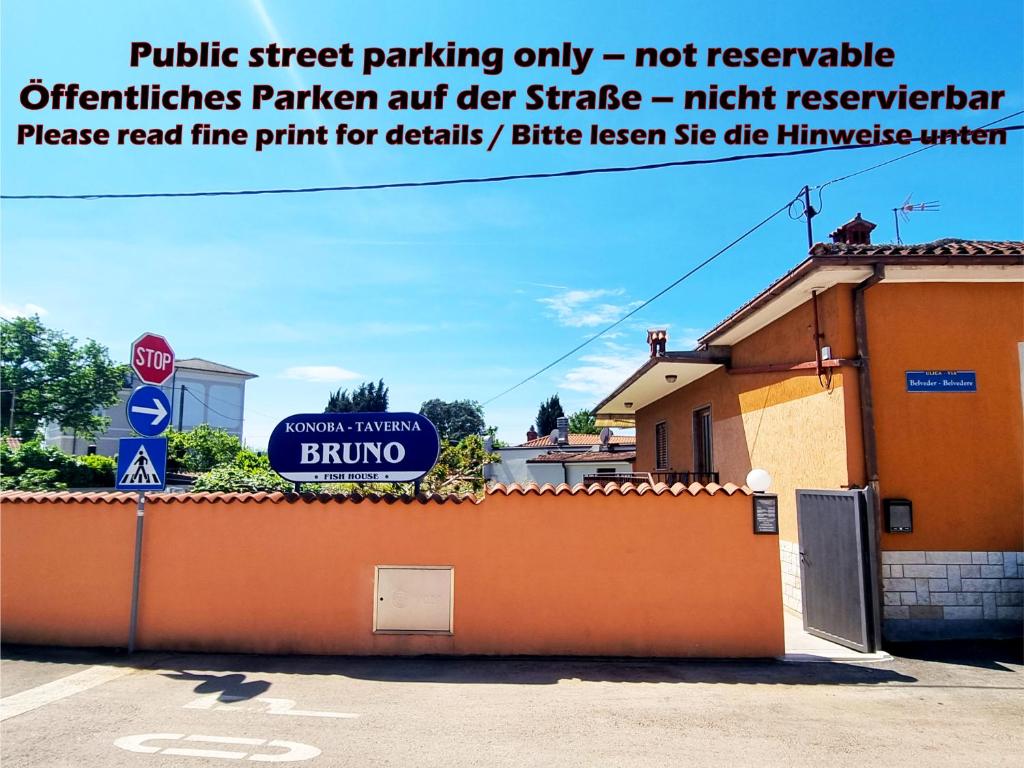 a stop sign and a building with a sign on it at Bruno's Rooms in Bašanija