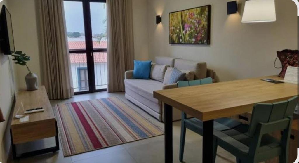 a living room with a table and a couch at QUINTA santa BÁRBARA RESORT in Pirenópolis