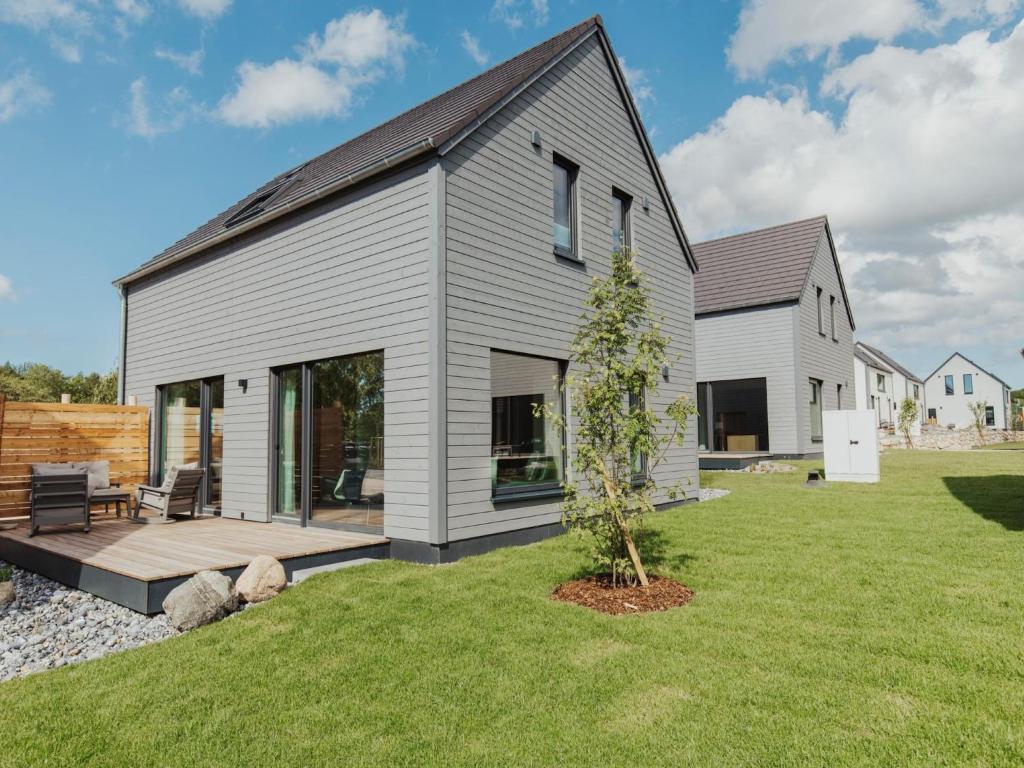 a gray house with a black roof at skandinavisch eingerichtetes Familienferienhaus in Sagard