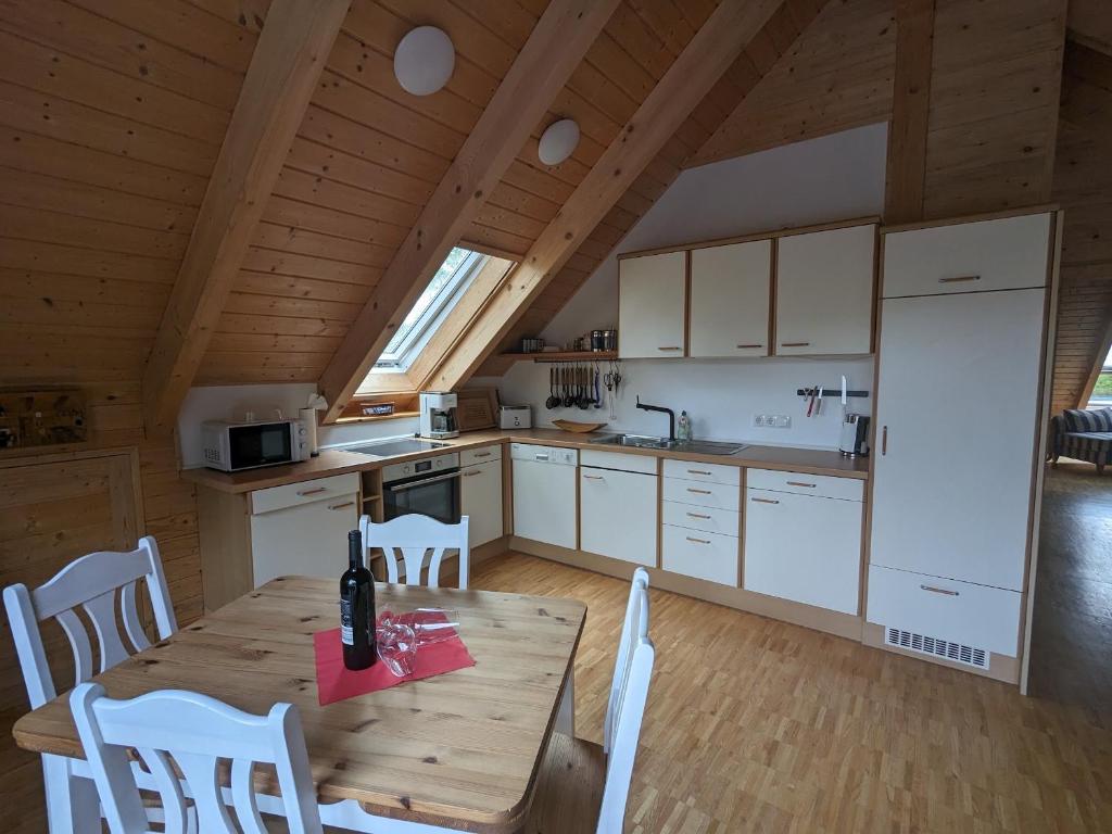 a kitchen with a wooden table and white cabinets at Borner Holzhaus in Born