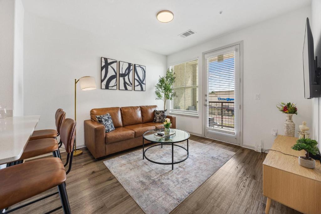 a living room with a couch and a table at Chic 1BR Frisco Stay, King & Sofa, Pool & Gym in Frisco