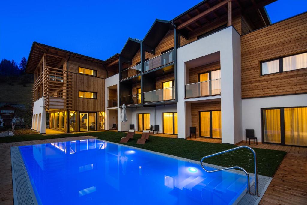 a house with a swimming pool in front of it at Mölgg Dolomites Residence in San Vigilio Di Marebbe