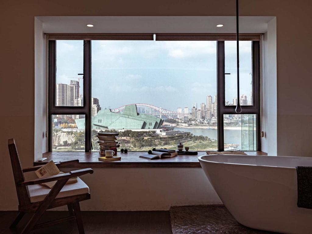 a bathroom with a bath tub and a large window at Boys2men in Chongqing
