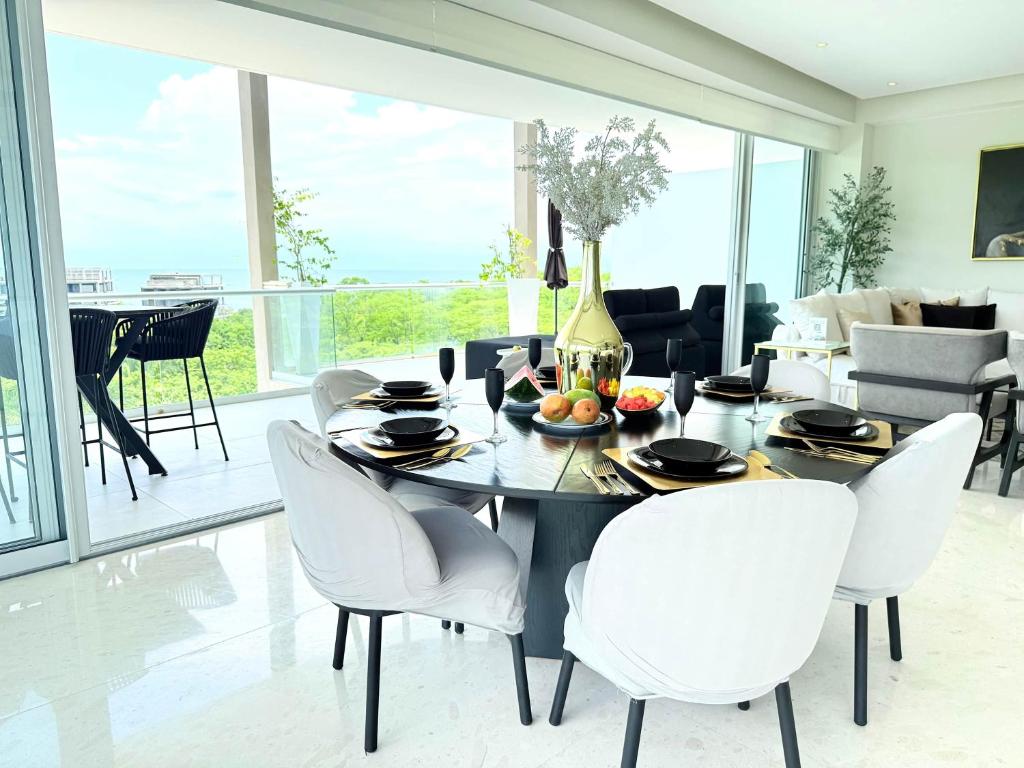 ein Esszimmer mit einem Tisch und weißen Stühlen in der Unterkunft Luxury 2BR Bolongo Ocean View Private Beach in Higuera Blanca