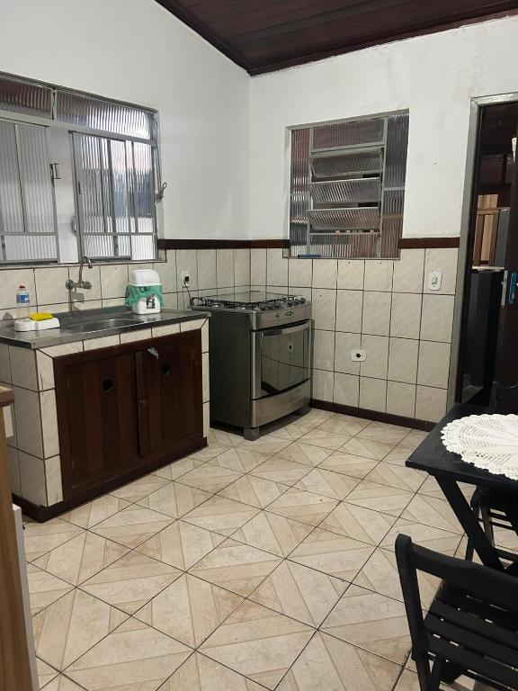a kitchen with a sink and a stove top oven at Apartamento no centro de Paraty in Paraty