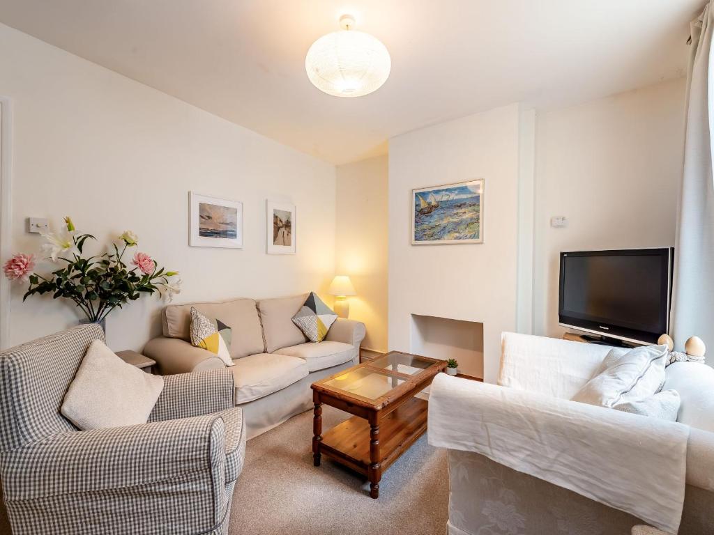 ein Wohnzimmer mit zwei Sofas und einem Fernseher in der Unterkunft Wellspring Cottage in Whitstable