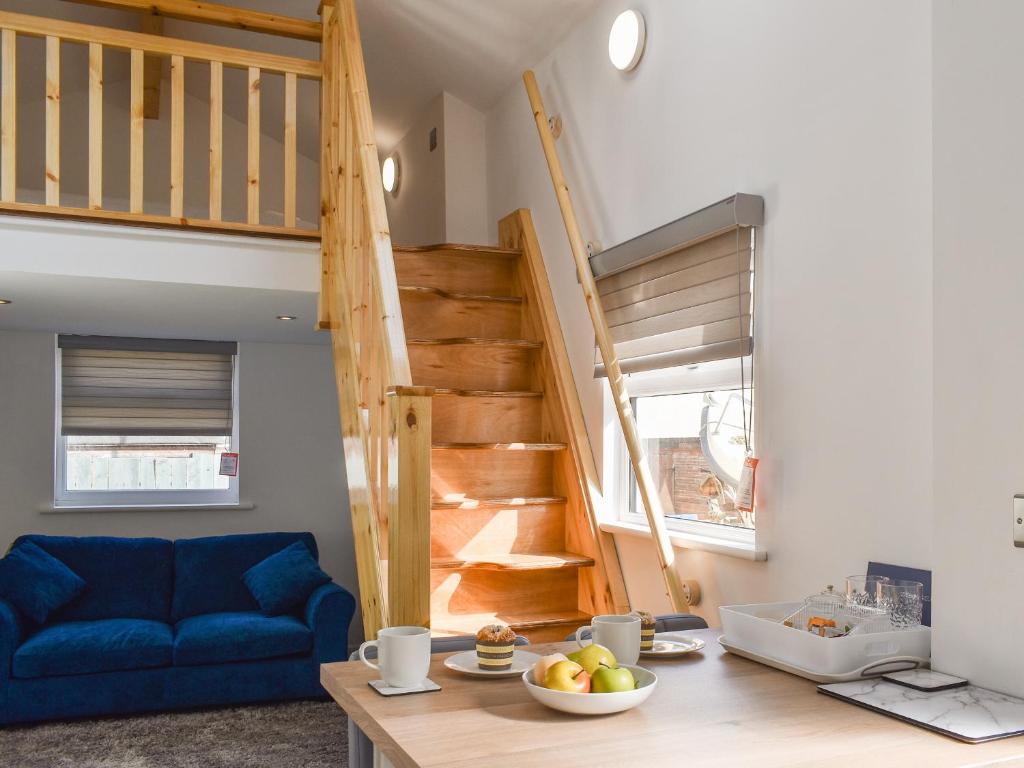 ein Wohnzimmer mit einem blauen Sofa und einer Treppe in der Unterkunft The Boat House in Padstow