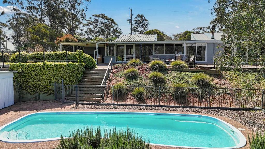 a home with a swimming pool in front of a house at Englewood Ridge in Lovedale