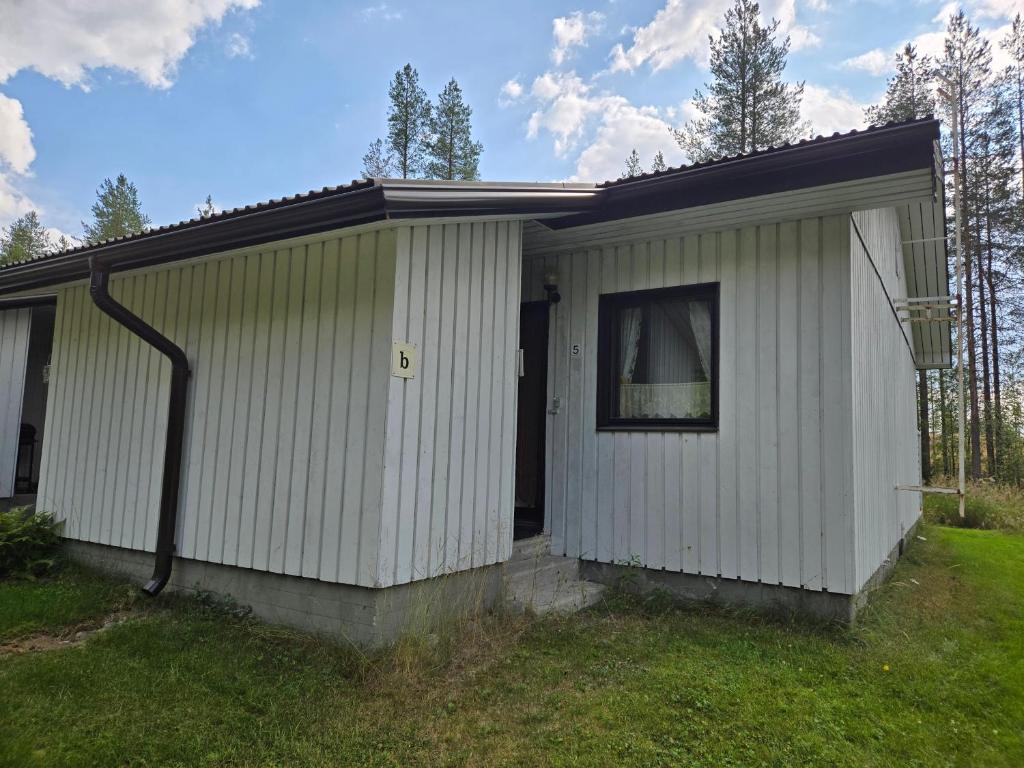 a small white house with a gutter at Hossanraitti in Kuusamo