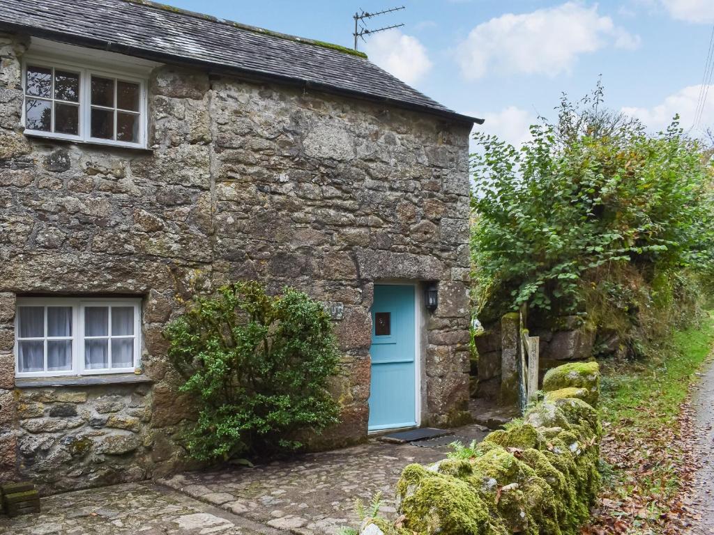 ein altes Steinhaus mit blauer Tür in der Unterkunft Scrumpy Cottage in Bodmin