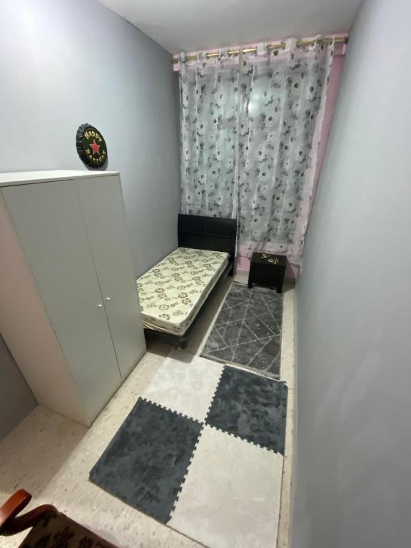 a small room with two beds and a curtain at Sharing apartment in Abu Dhabi