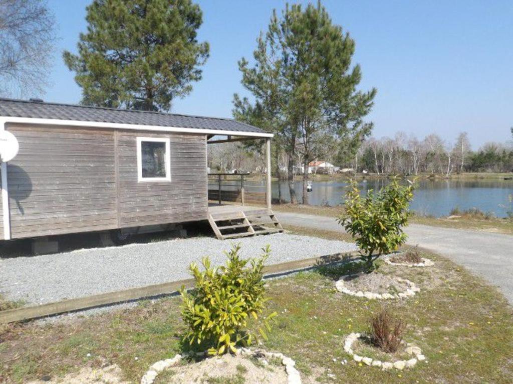 a small house with a porch next to a lake at Chalet de 22m² avec Terrasse pour 4 personnes - API-1-52-414 in Saint-Sornin