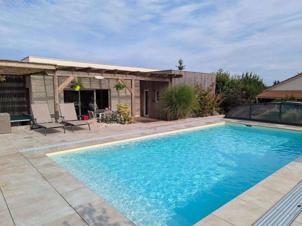ein Swimmingpool im Hinterhof eines Hauses in der Unterkunft Maison de vacances raffinée avec terrasse et piscine partagée - FR-1-589-837 in Dounoux