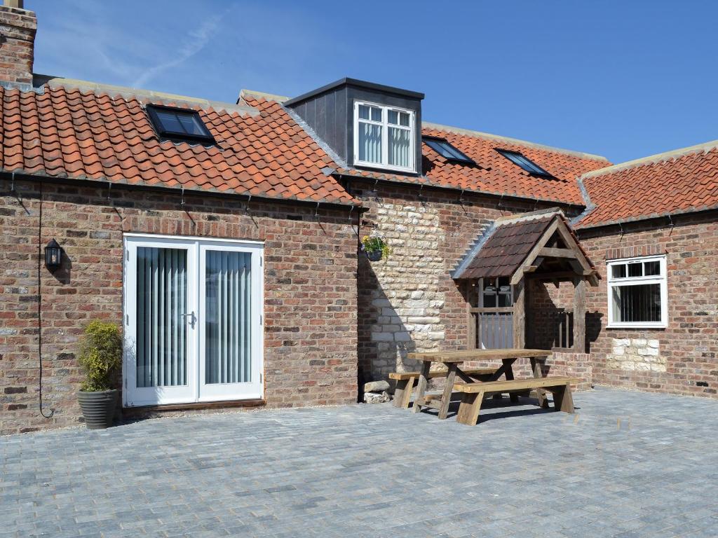 a brick building with a picnic table in front of it at Christine Cottage in Flamborough