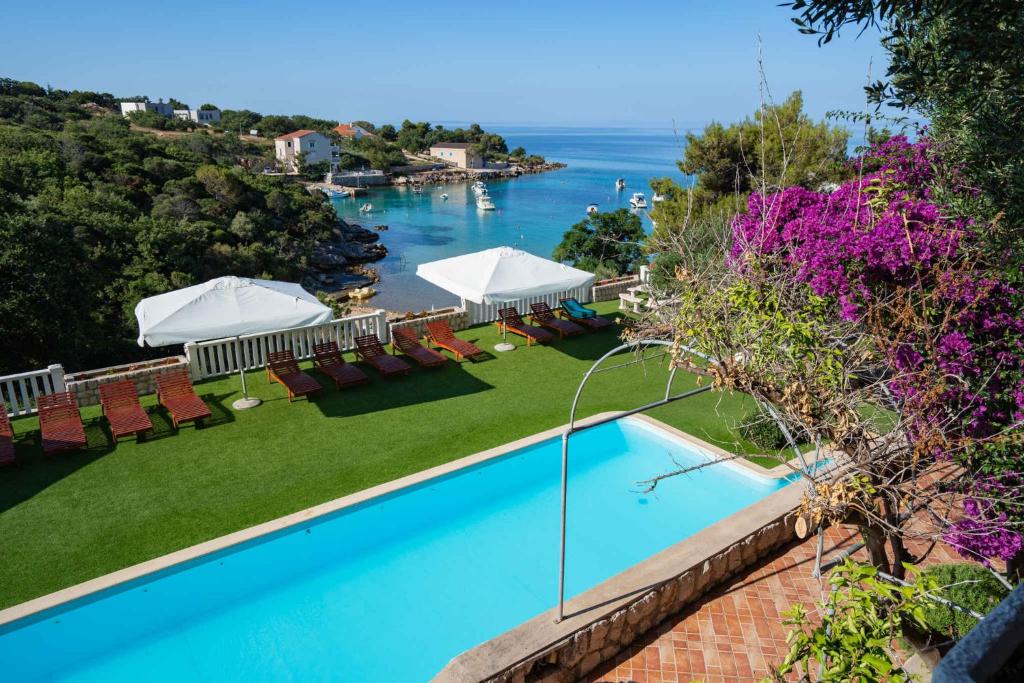 a swimming pool with chairs and a view of the ocean at Apartments in Potocnica - Insel Pag 47657 in Potocnica