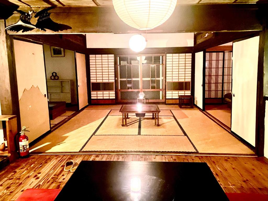 a large room with a table in the middle of it at KOMINKA guest house in Omachi