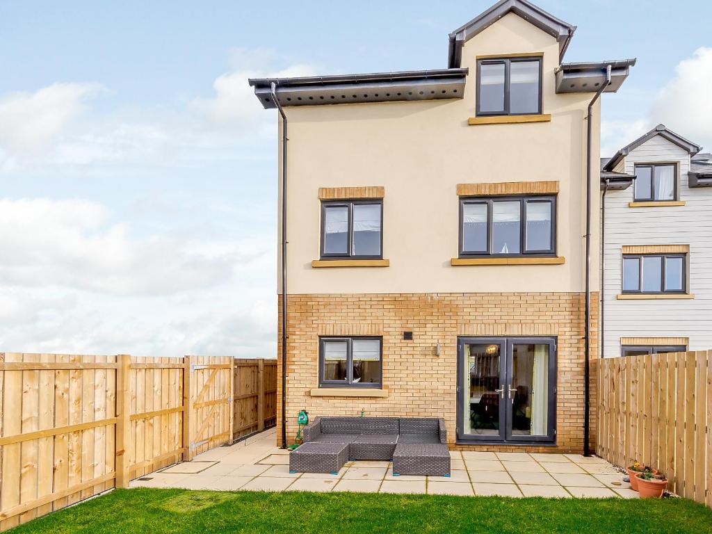 ein Haus mit einem Holzzaun in der Unterkunft Coastal Retreat in Amble