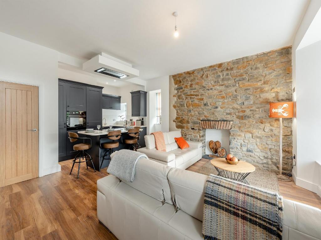 a living room with a couch and a stone wall at Sandy View - Uk43056 in Saundersfoot