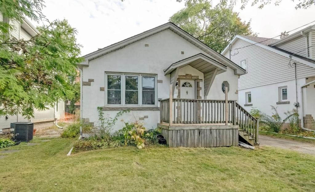 a white house with a porch and a fence at Entire Two Bedrooms Bungalow- Walking distance to Burlington Downtown- Sleeps 6 in Burlington