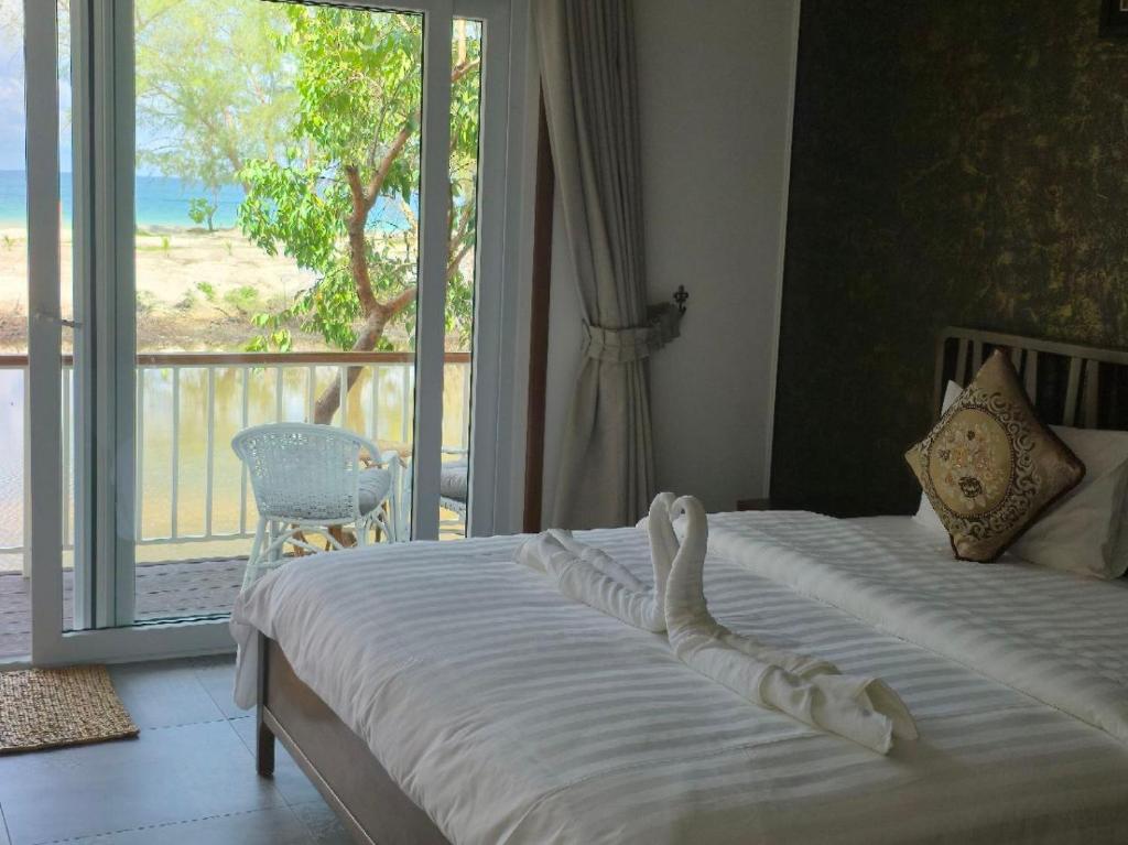 a bedroom with two beds and a view of the ocean at White Beach Resort Longset in Koh Rong Island