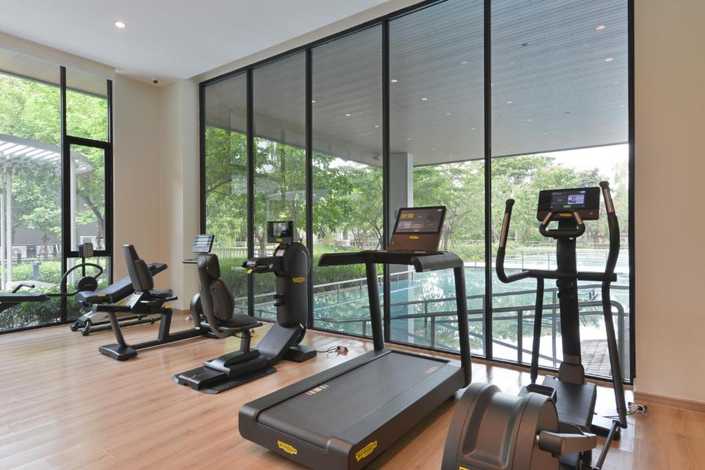 A bright glass-walled gym overlooks the landscaped pool area.