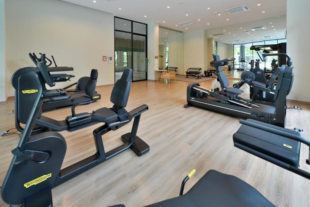 A spacious fitness room contains cardio and resistance machines on a wood floor.