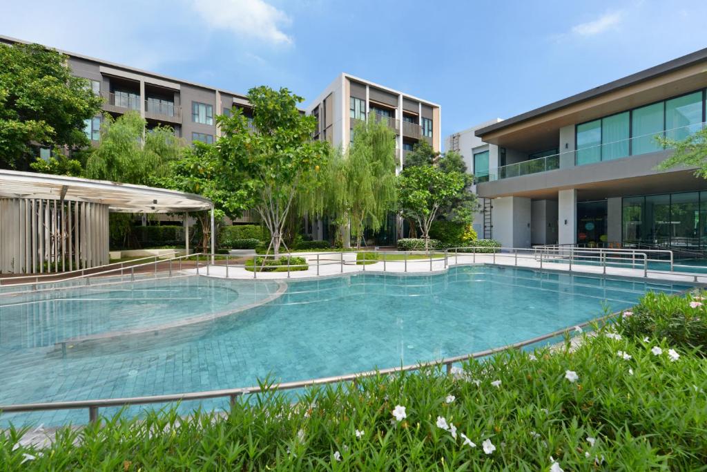 A broad outdoor pool sits beside the hotel’s glass-fronted building.