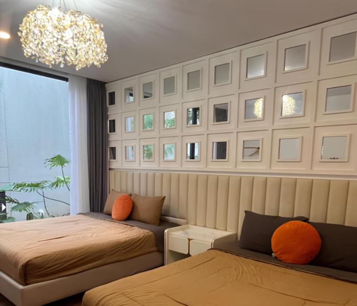 a bedroom with two beds and a chandelier at Aimo Villa in Ciburial