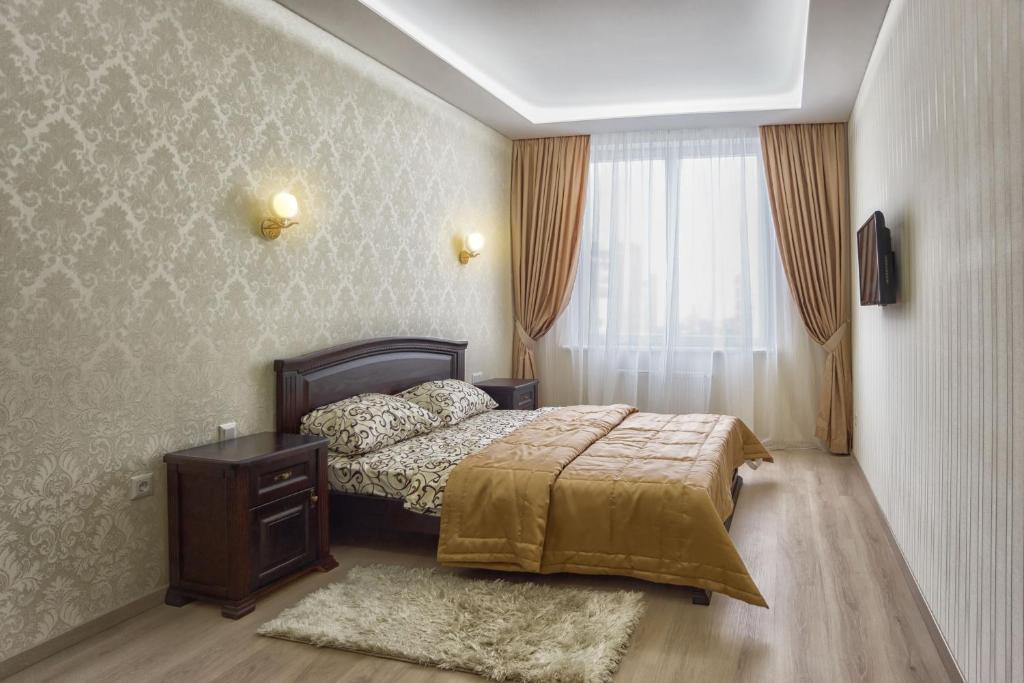 a bedroom with a bed and a dresser and a window at Golfstrim in Odesa