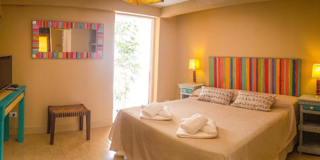 1 dormitorio con 1 cama con toallas en Tierra Virgen Apartments en Purmamarca