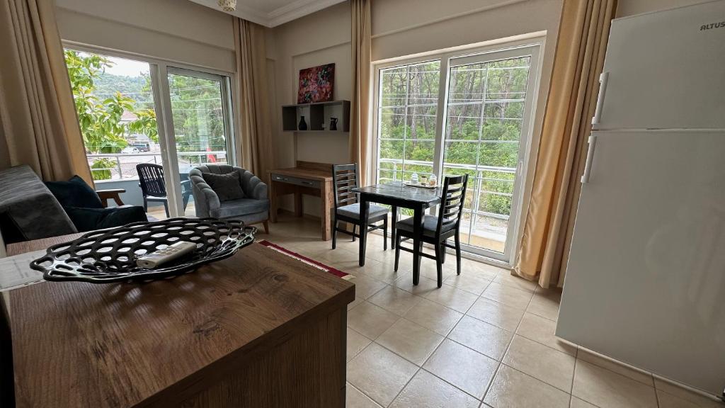 a living room with a refrigerator and a table and chairs at Kemer House Apartments in Kemer