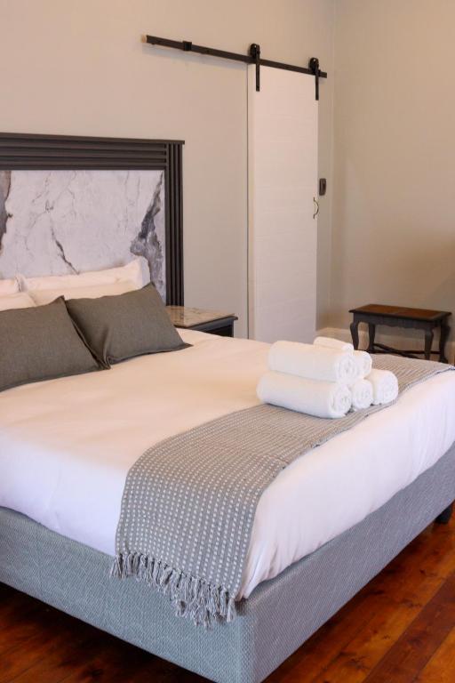 a bedroom with a large bed with towels on it at The Essenwood Collection in Durban