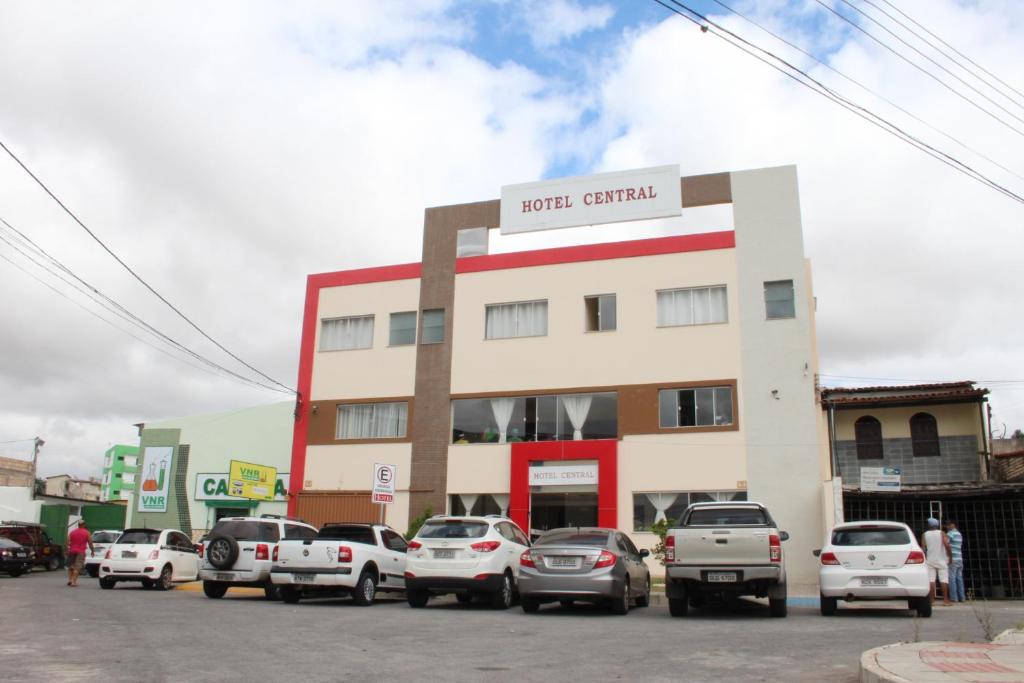 um parque de estacionamento com carros estacionados em frente a um edifício em Hotel Central em Vitória da Conquista