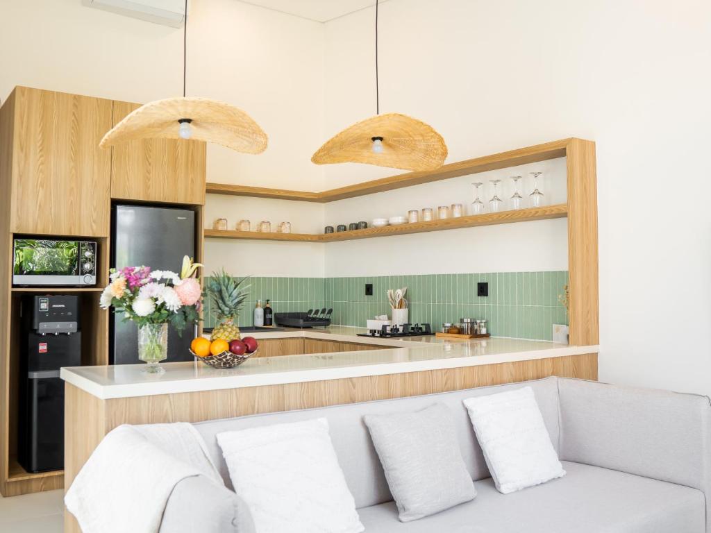 a living room with a couch and a kitchen at Aquae Villas - Palma - Luxury and Cozy 1bdr Villa - Kuta Lombok in Kuta Lombok