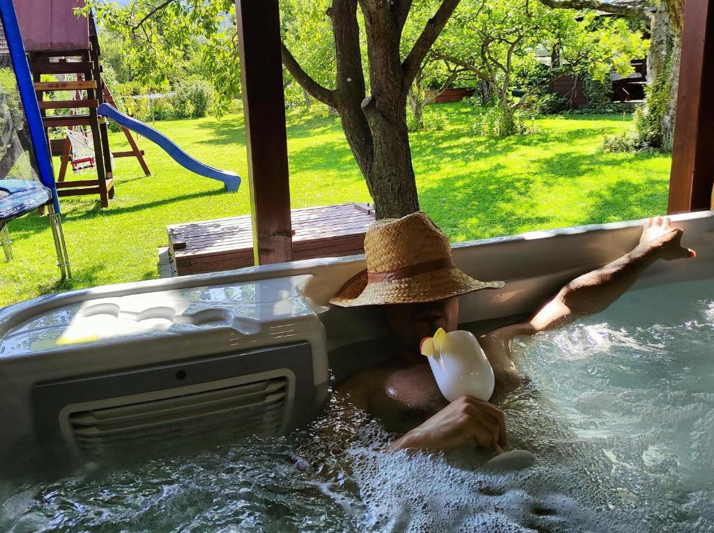 a man wearing a hat in a hot tub at AGAMI T in Pavčina Lehota