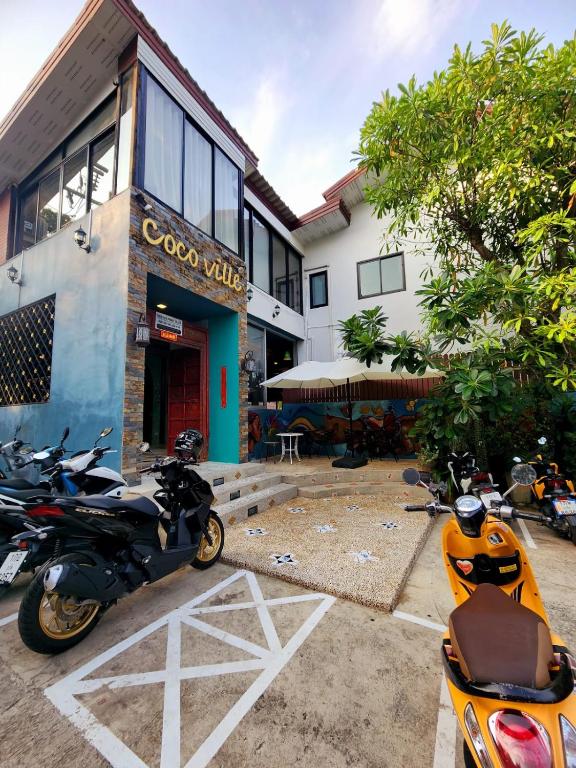 查龙Cocoville Phuket - SHA Plus的一群摩托车停在一栋建筑物前
