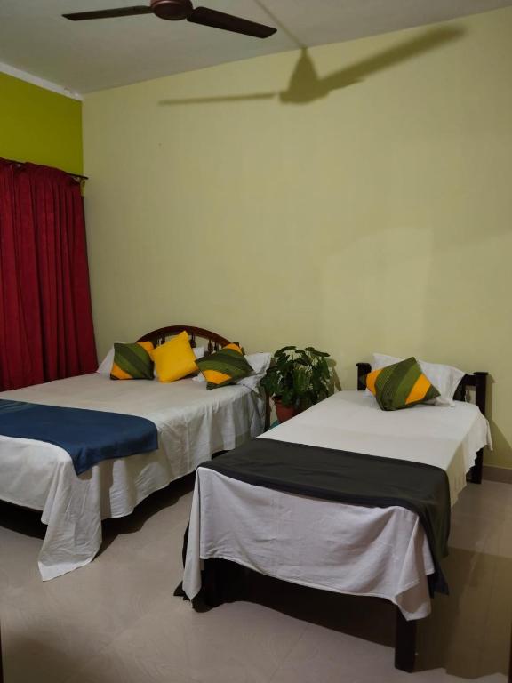 two beds in a room with a ceiling at AS Villa Homestay in Varkala