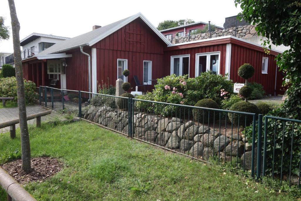 a fence in front of a red house at Ferienhaus in Waren an der Müritz in Waren